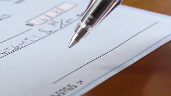 Macro Shot Of A Hand Writing A Check