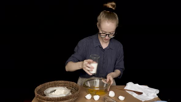 Young Woman Cooking on Isolated Black Background