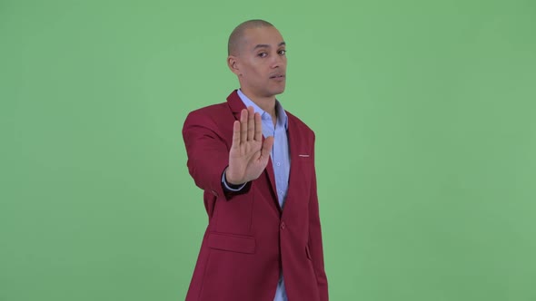 Serious Bald Multi Ethnic Businessman with Stop Gesture