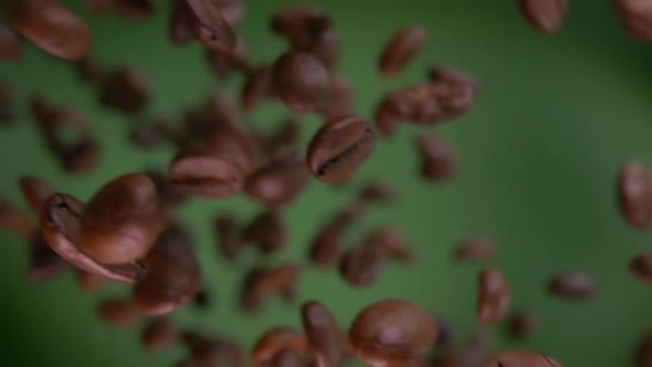 Closeup of the Roasted Coffee Beans Rotating on the Olive Green Background