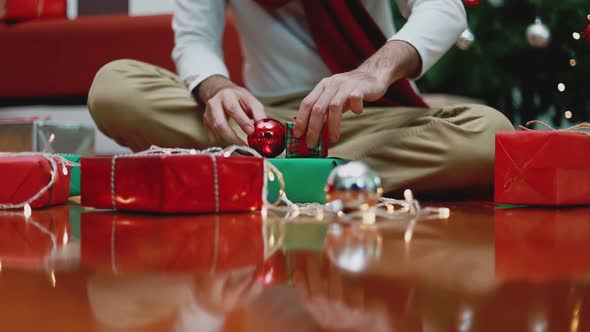 Young Asian man making a gift box in the living room at home.