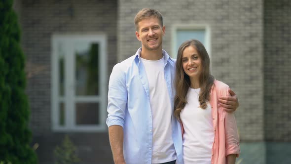Happy Couple Standing Against New Bought House