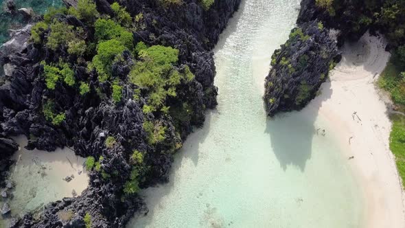 Aerial of Hidden Beach pedestal down tilting up on limestone cliffs in El Nido, Palawan, the Philipp