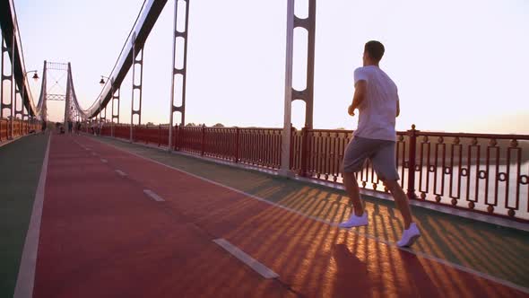 Jogger Is Running Along Pedestrian Bridge