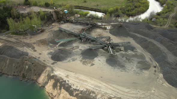 Aerial view basalt quarry of open pit mine machines with sifters conveyor belts