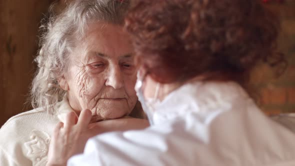 Woman Doctor with Stethoscope Listens to an Elderly Patient Old Woman and Talks Comforting Her