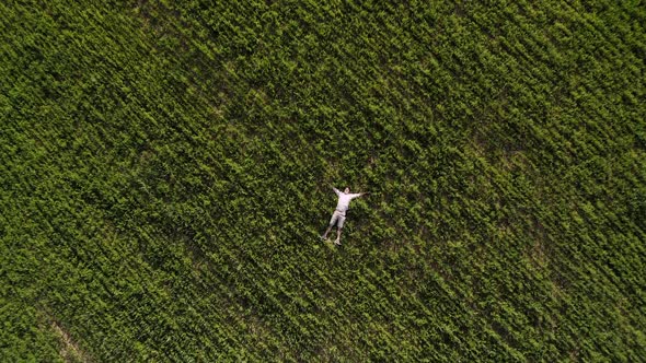 Man Lying on a Green Field