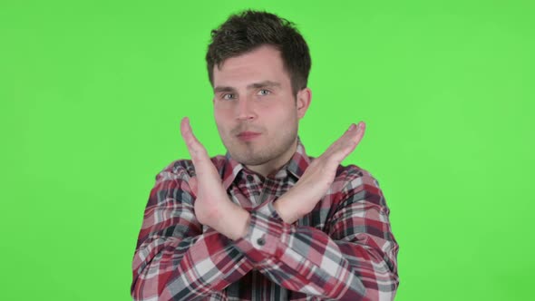 Portrait of Young Man Showing No Sign By Arm Gesture Green Chroma Screen