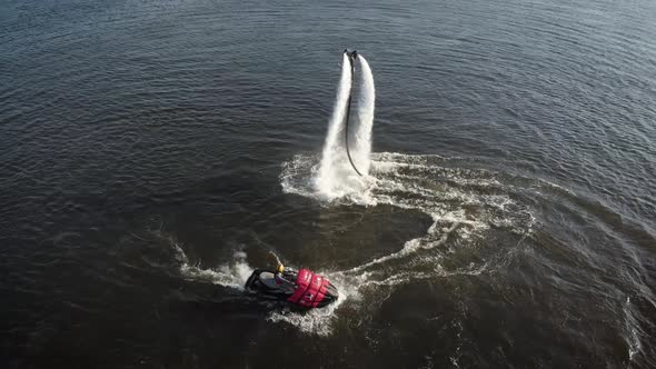 Flyboard Instructor Is Flying Up and Down, Performing Flip on Lake, Aerial View on Sportsmen