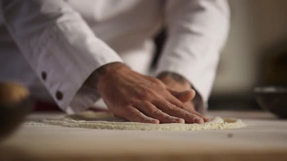 Baker Hands Cooking Dough Pizza on Flour Wooden Board in Kitchen Restaurant