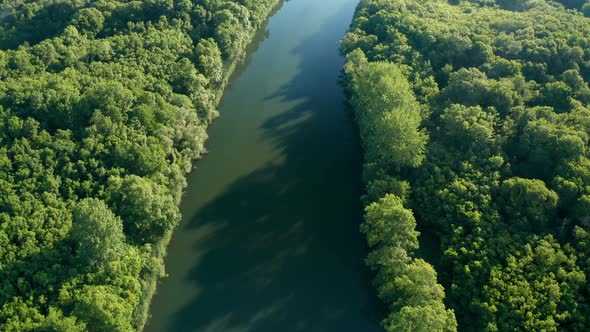 Drone flight above calm green waters of a wide river