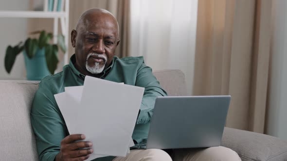 African American Businessman Elderly 60s Bald Man Sitting at Desk Typing on Laptop Manage Household