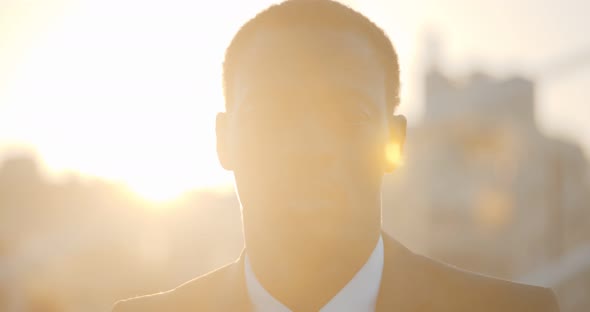 Close Up Portrait of Afroamerican Businessman in Formal Suit Looking at Camera Outdoors in Sunlight