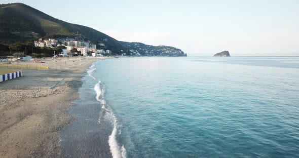 A drone flies over a Mediterranean sandy beach in Genoa, Italy. aerial shot.