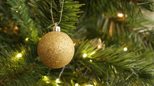 Golden color Christmas ornament close-up 4K 2160p 30fps UltraHD footage - Sparkling  gold bauble on 