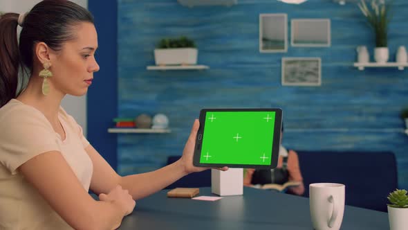 Caucasian Female Looking at Tablet Computer with Mock Up Green Screen for Online 