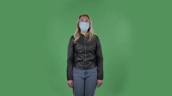 Portrait of Beautiful Young Upset Woman in Medical Protective Face Mask Is Looking at Camera Gets