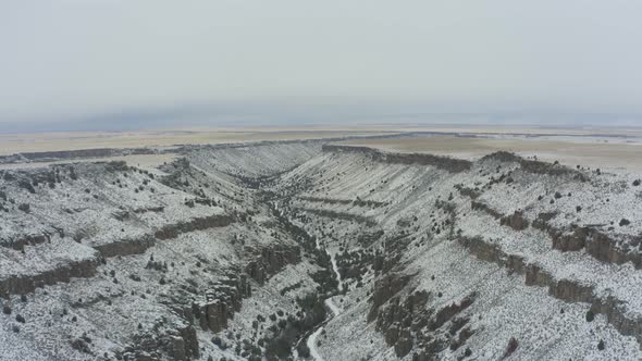 Slowly rising drone shot of snowy canyon in Idaho