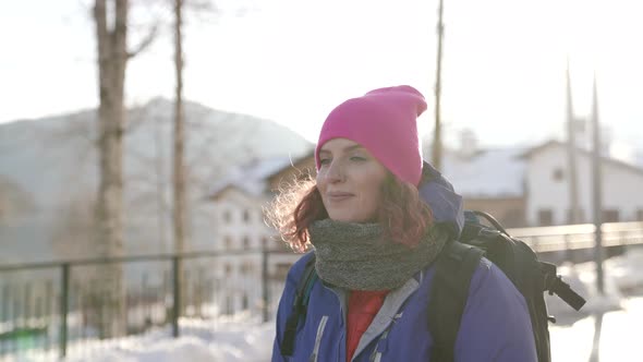 Portrait of a Woman in a Pink Hat and Blue Jacket Walking Smiling