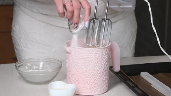 A Woman Adds Ingredients To A Container, Makes Dough.