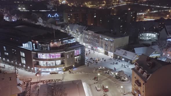 Aerial forward over Zakopane Krupowki district in wintertime at night with snow on streets. Poland
