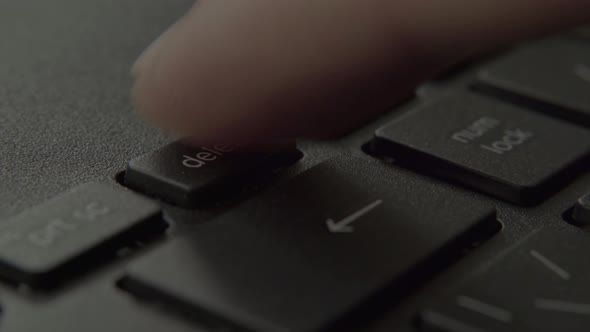 The Finger Presses the Backspace Button on the Keyboard