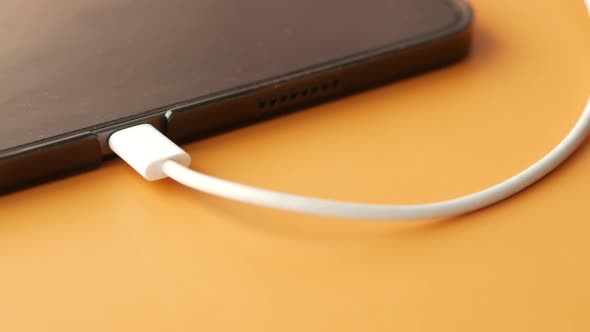 Charging Digital Tablet with a Cable on Color Background