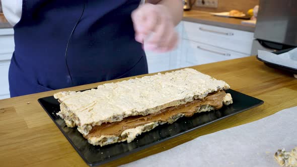 The Cook Puts Second Layer of the Meringue Cake