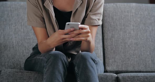 Close Up Womans Hands Holding Smartphone on Gray Sofa at Home, Using Mobile Network To Surf Internet