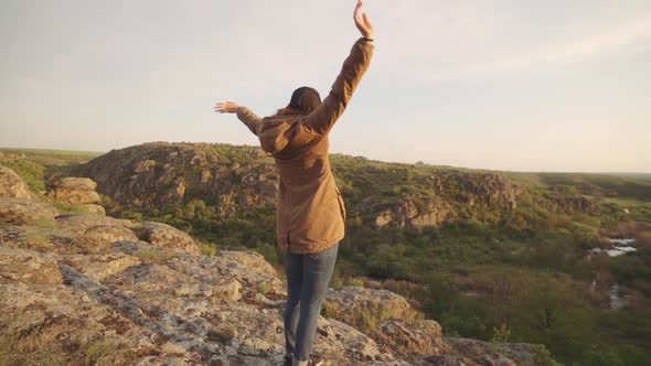 A Young Woman Traveler Walks in the Mountains at Canyon