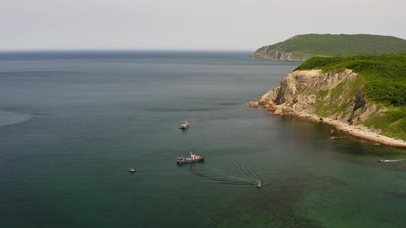 Drone View of a Fishing Schooner Anchored Near a Beautiful Rocky Promontory