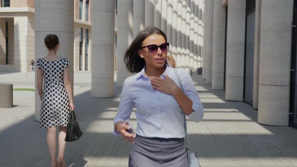 African Businesswoman in Hurry Checking Time on Smartphone Walking Downtown