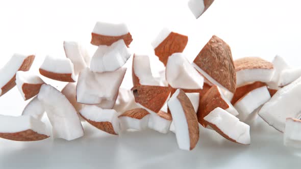 Super Slow Motion Shot of Fresh Coconut Pieces Falling on White Background at 1000Fps