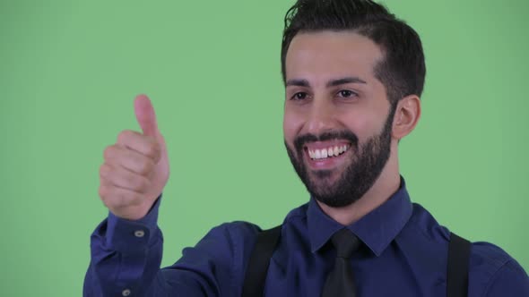 Face of Happy Young Bearded Persian Businessman Giving Thumbs Up