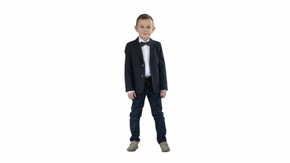 Smiling little boy in formal clothes standing on white background.
