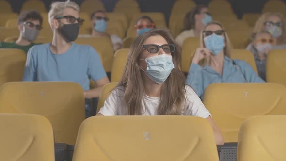 People in Face Masks Watching 3d Film in Cinema on Coronavirus Quarantine. Film-lovers in 3d Glasses