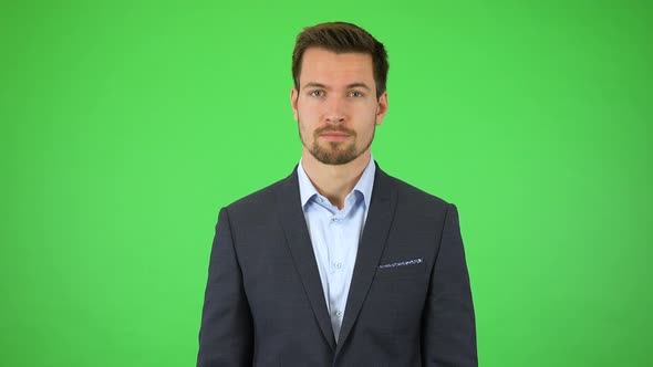 A Young Handsome Businessman Throws Out His Hands and Looks Around Helplessly - Green Screen Studio