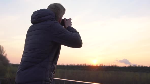 A person is taking photos while standing on a viewing platform.