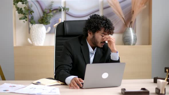 Pensive Tired Successful Curlyhaired Indian Ceo Top Manager or Businessman in Formal Suit Sitting at