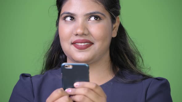 Young Overweight Beautiful Indian Businesswoman Against Green Background