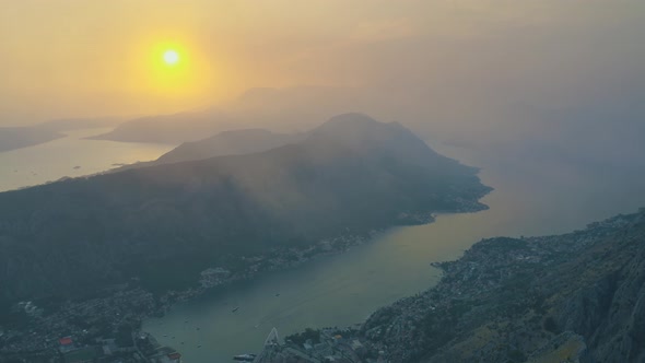 Sunset with fog view of Kotor bay and mountains in Montenegro. Aerial drone view 4K