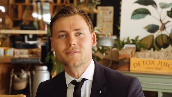 Handsome Businessman Smiling To Camera In Cafe