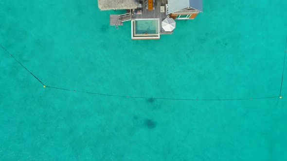 Aerial drone view of a luxury resort and overwater bungalows in Bora Bora tropical island