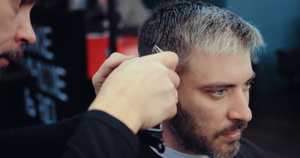 Grayhaired Man is Cut Hair at a Hair Salon