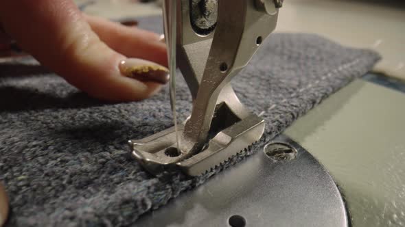 Seamstress Sews Woolen Fabric on Sewing Machine Advances Fabric with His Fingers