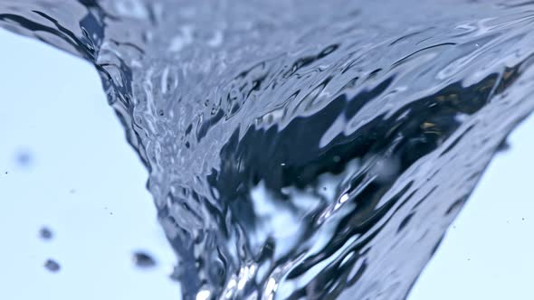 Super Slow Motion Detail Shot of Water Whirl on Light Blue Background at 1000Fps