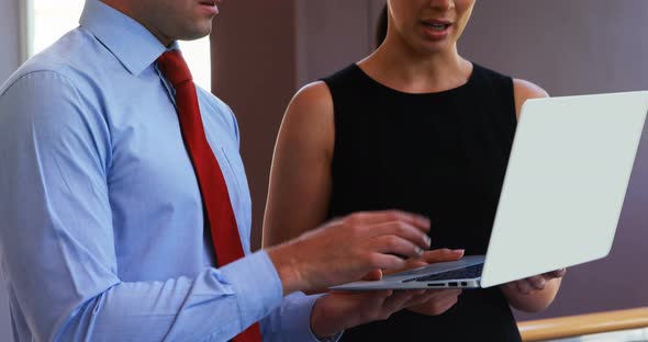 Executives discussing over laptop in conference centre 4k