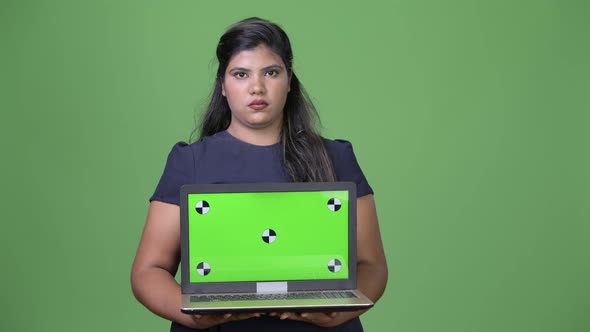 Young Overweight Beautiful Indian Businesswoman Against Green Background