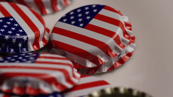 Rotating shot of bottle caps with the American flag printed on them 