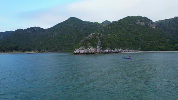 A fisherman is sailing in the sea among the islands near the coast.